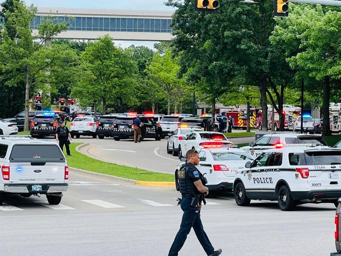 Dozens of police vehicles are parked on a road divided by a grassy median