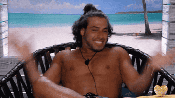 A GIF of Kem Cetinay clapping his hands excitedly in the beach hut of Love Island season three