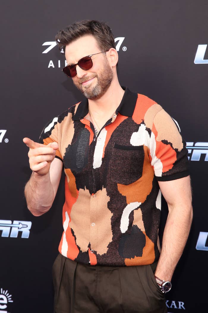 Smiling Chris on the red carpet with sunglasses and a colorful short-sleeved print shirt