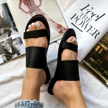 a model wearing the sandals in black