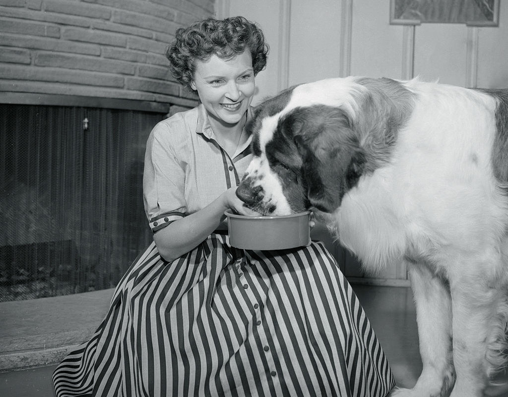 Betty White feeding a large dog