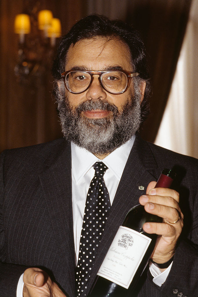 Francis Ford Coppola holding a bottle of wine