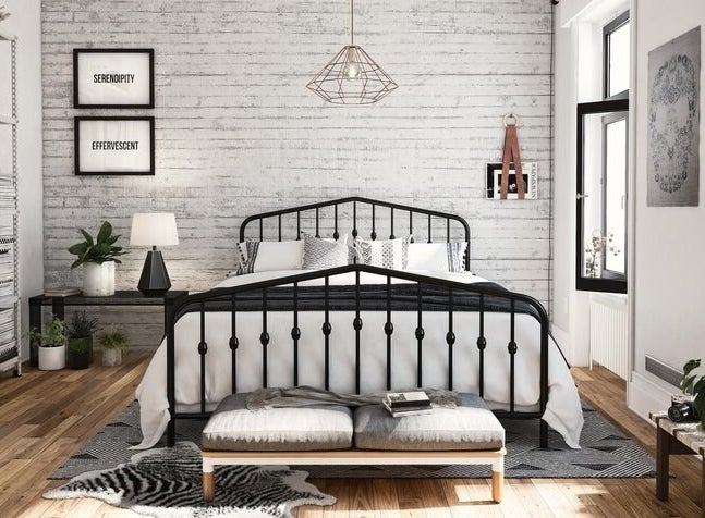 black metal bed frame with a headboard and foot board that each peak in the middle