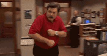 gif of ron swanson in parks and rec dancing across the room wearing a bright red shirt