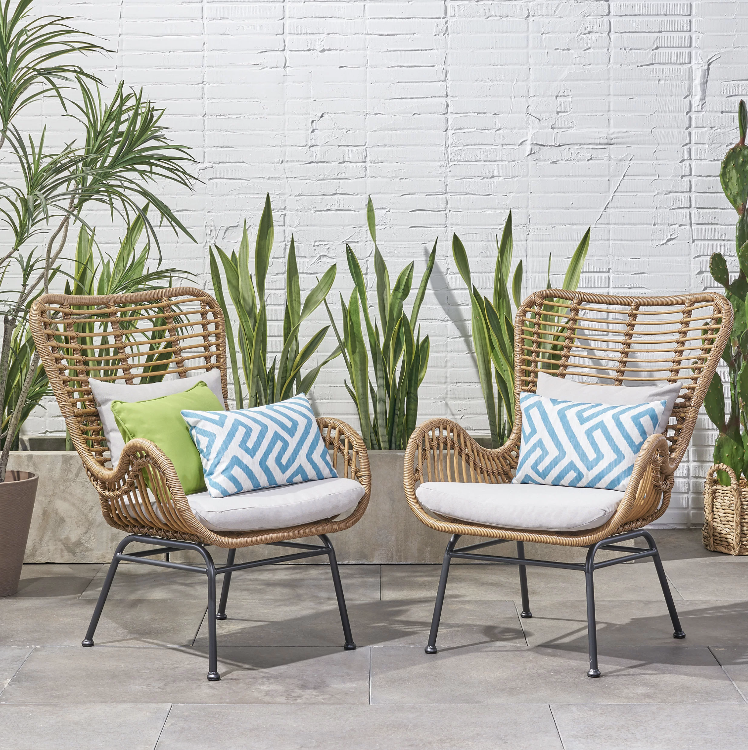 The two chairs on a tiled patio in front of plants