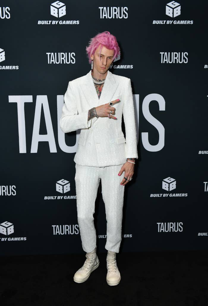 MGK in a wool suit, sneakers, pearl necklace and long dangling earring