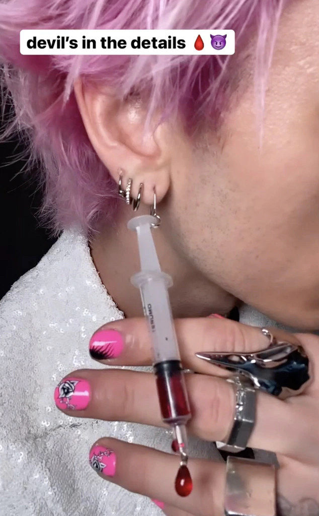 close up of MGK holding out the earring