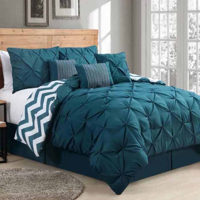 Teal comforter set on a bed in a bedroom