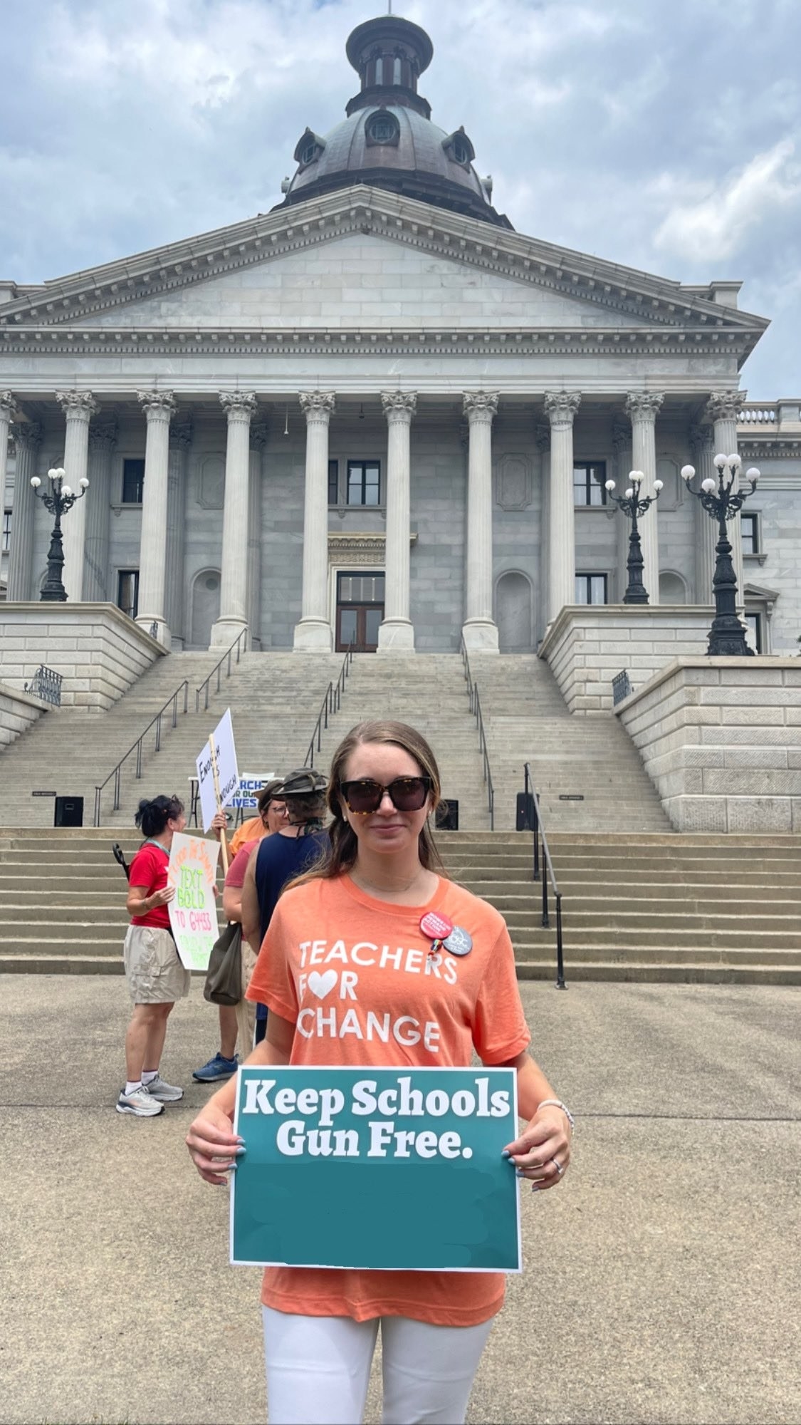 Emily Mayer protests gun violence and holds up the sign &quot;Keep schools gun free&quot;