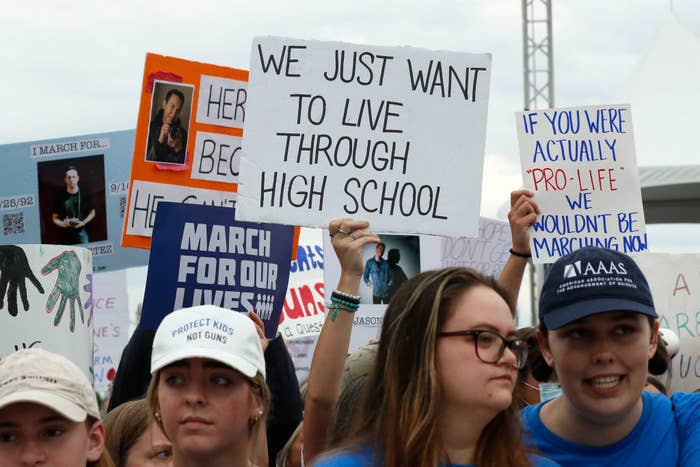 Young people holding up signs, including &quot;We just want to live through high school&quot;