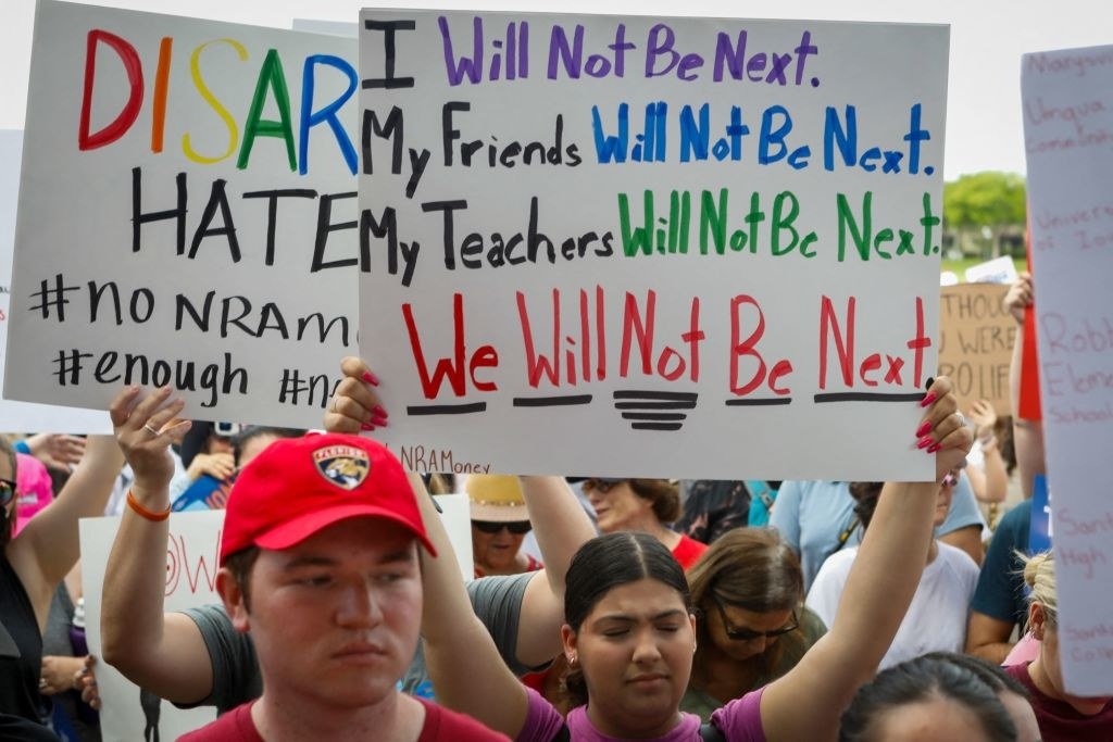 Young people holding signs, including &quot;I will not be next, my friends will not be next, my teachers will not be next, we will not be next&quot;