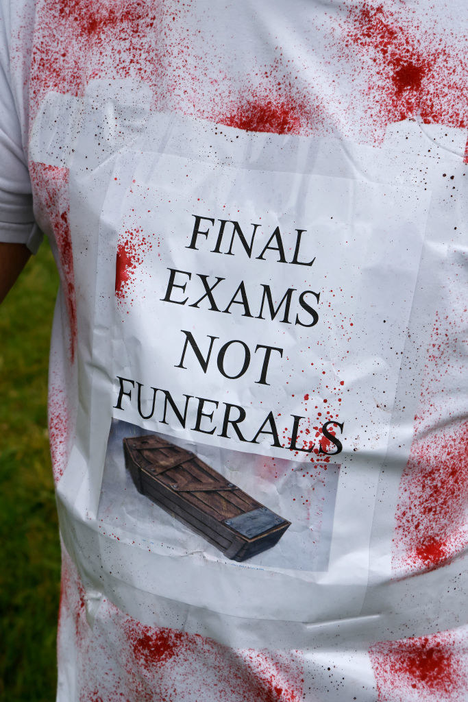 Someone wearing a shirt with what looks like blood spattered on it and the text &quot;Final exams not funerals&quot; along with a photo of a coffin