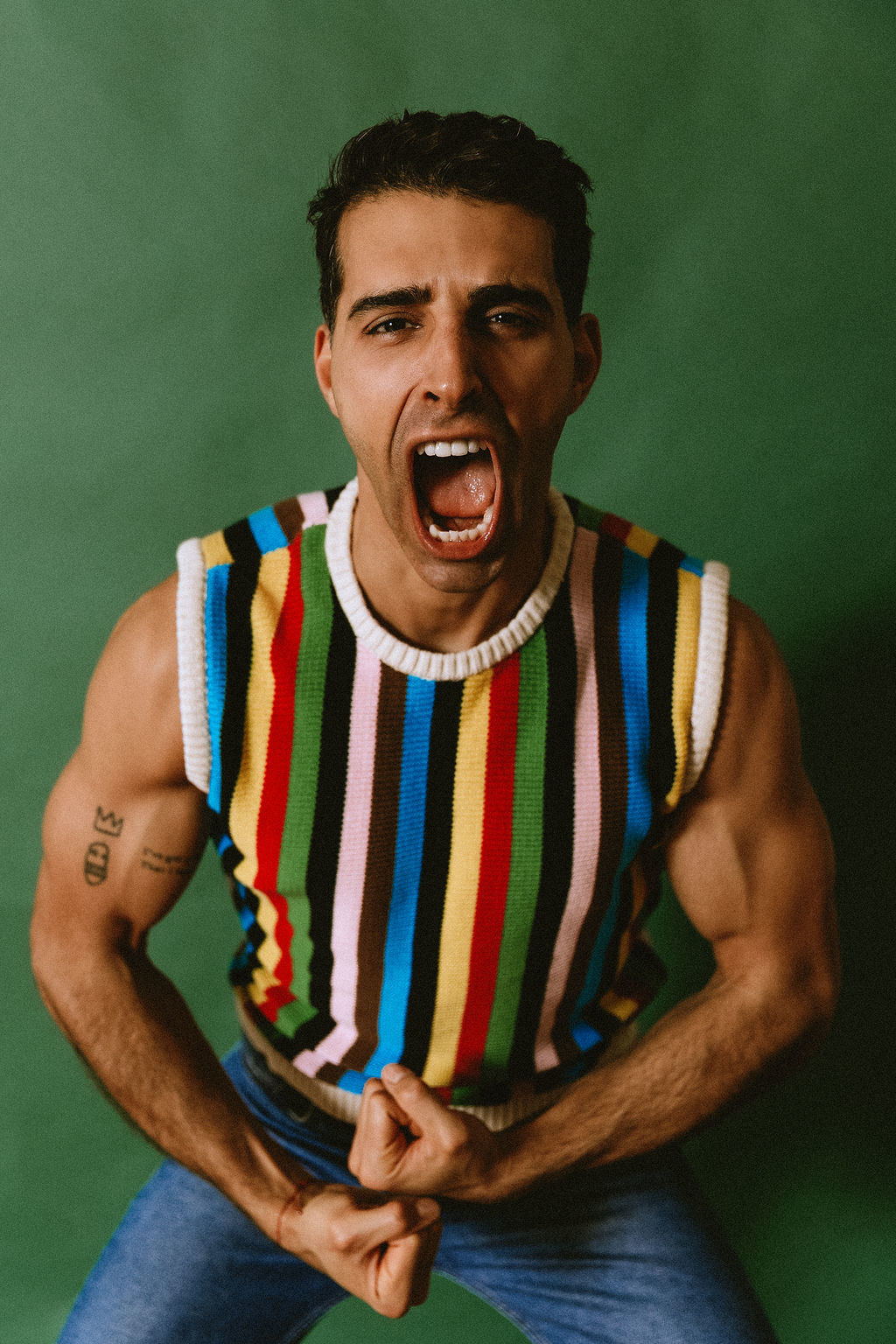 Samer Salem flexes in a colorful knit vest.