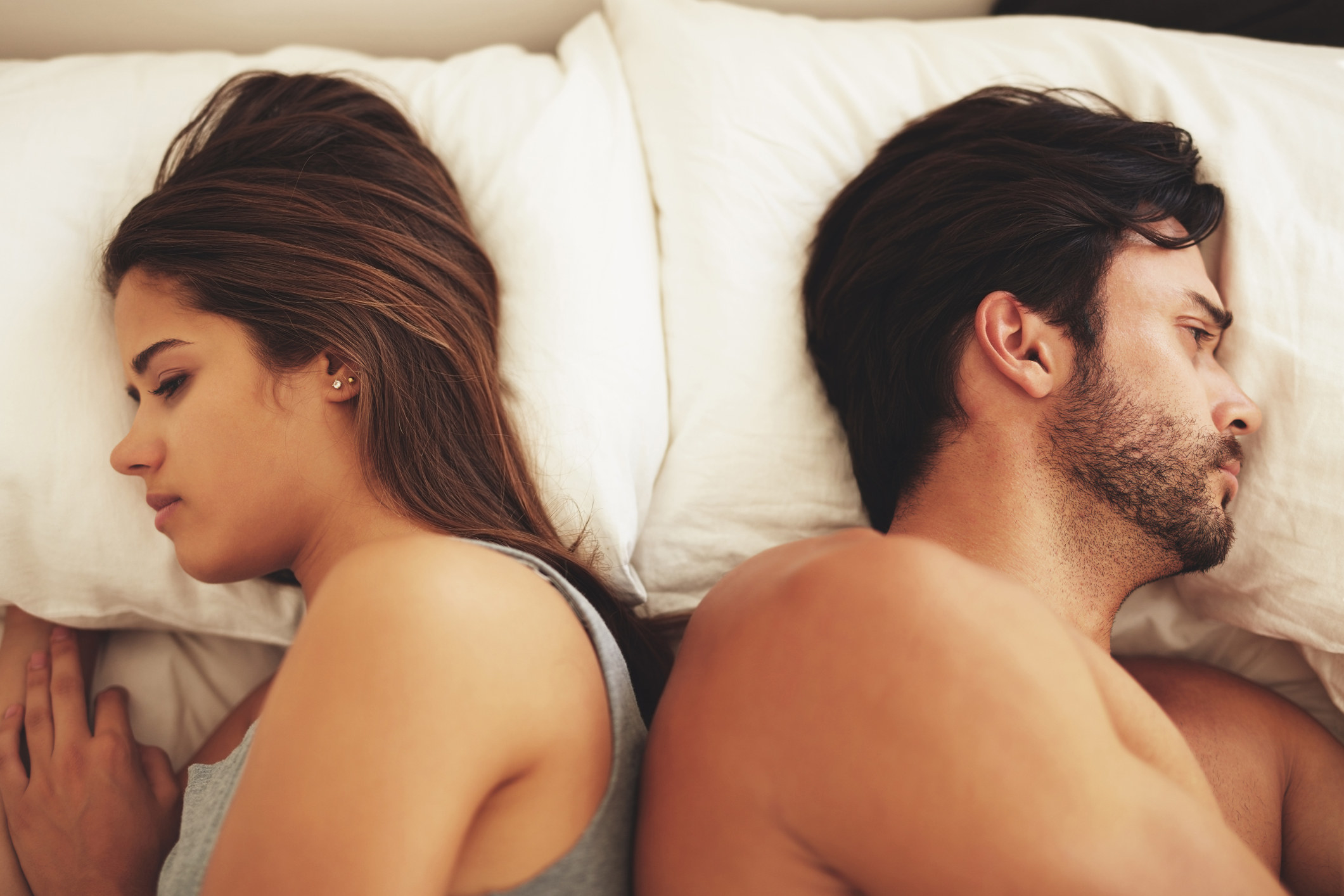 A couple ignores each other while laying in bed