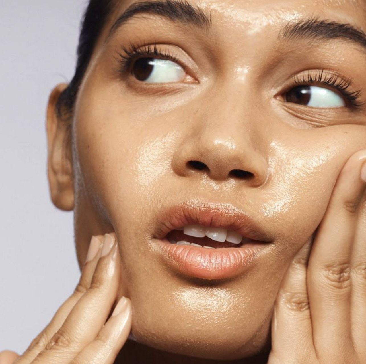 A person using cleansing balm on their face