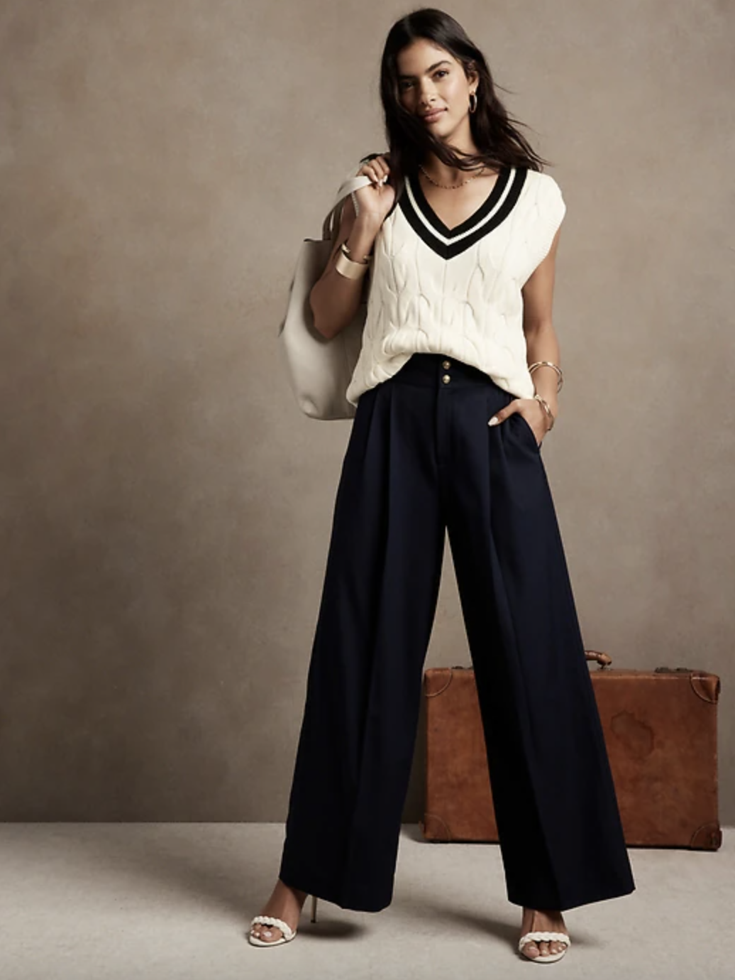 model wearing white cable knit vest and black pants