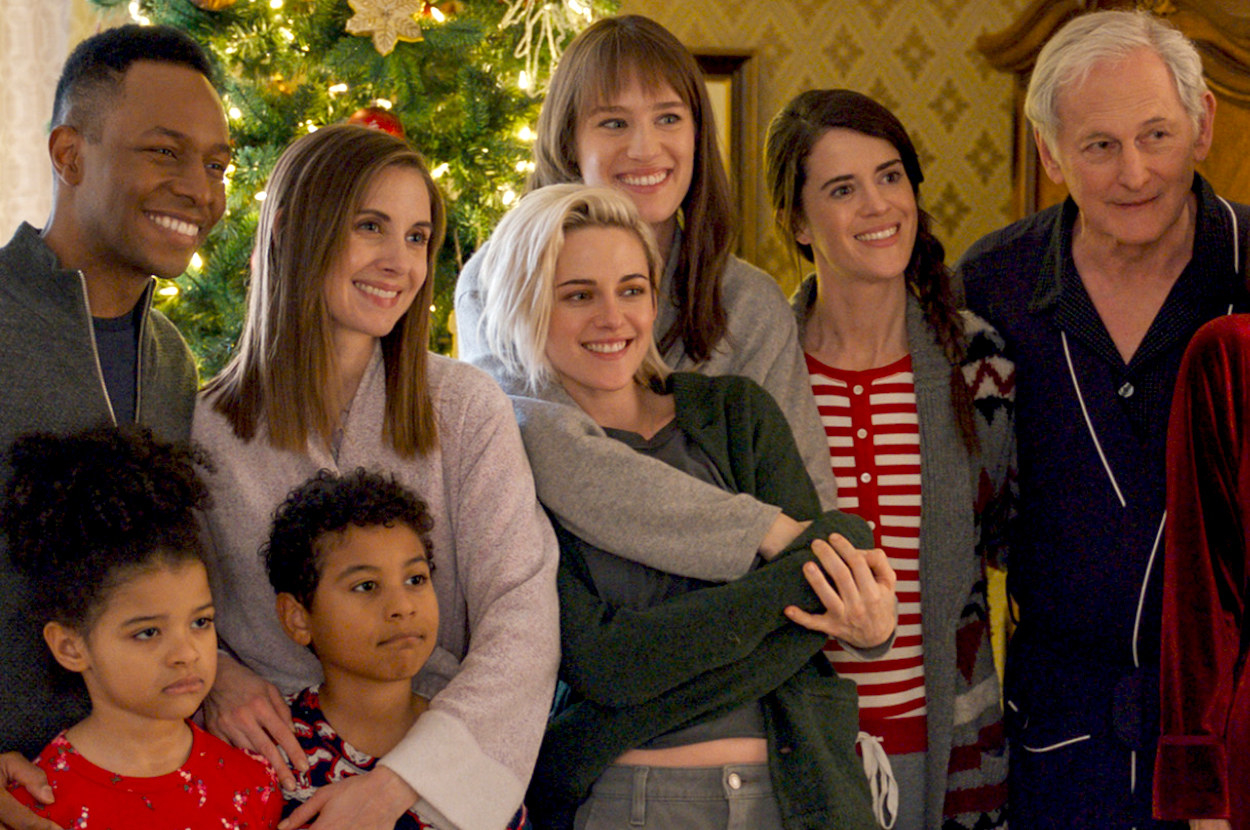 Several family members stand in a line looking happy and hugging