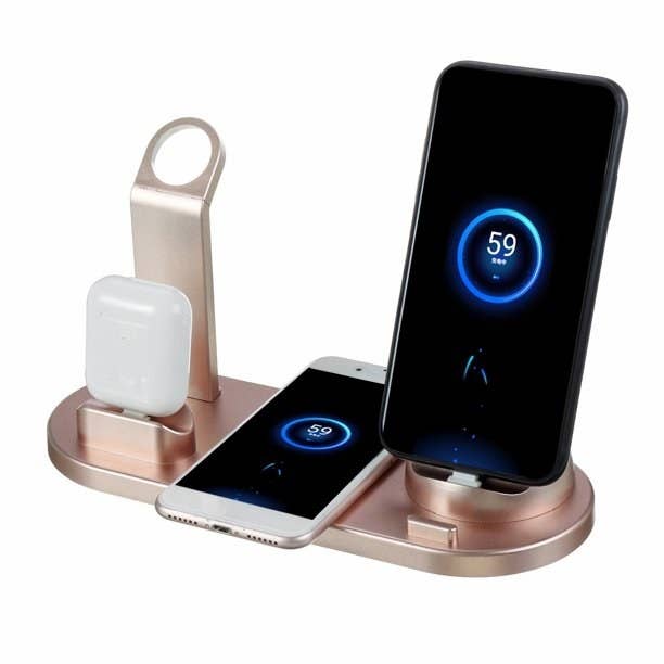 The rose gold charging stand powering up airpods in case, and two smartphones