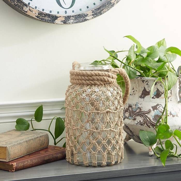 The twine covered glass jar candle opener resting on a shelf