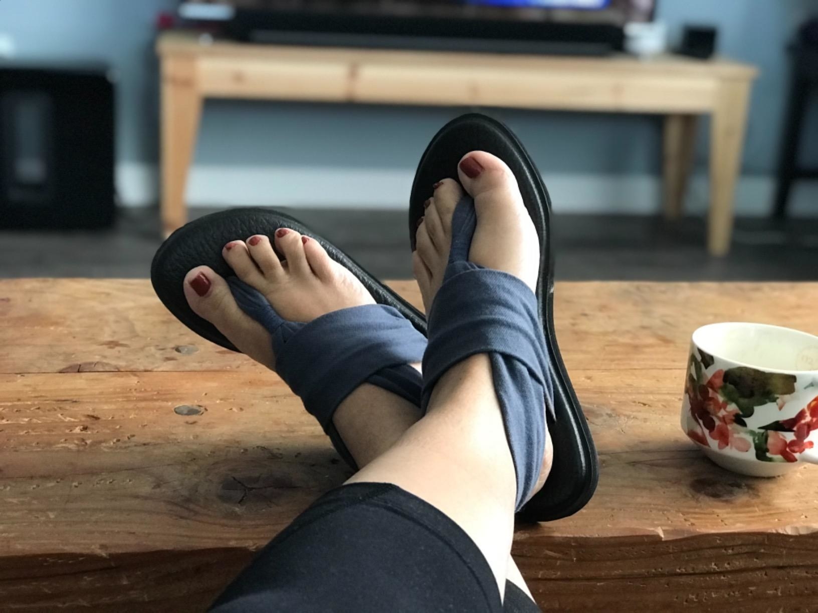 Reviewer is wearing the sling sandals in a dark grey