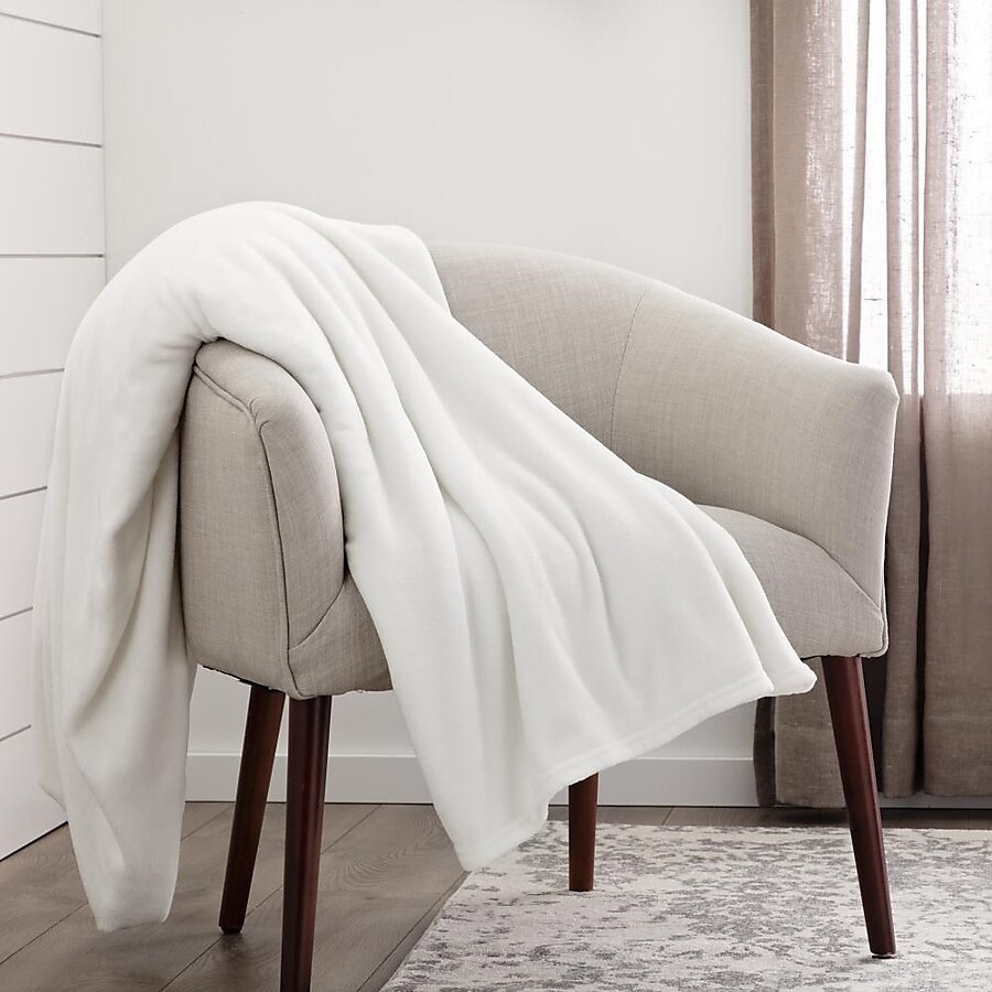 the white throw blanket draped over an accent chair
