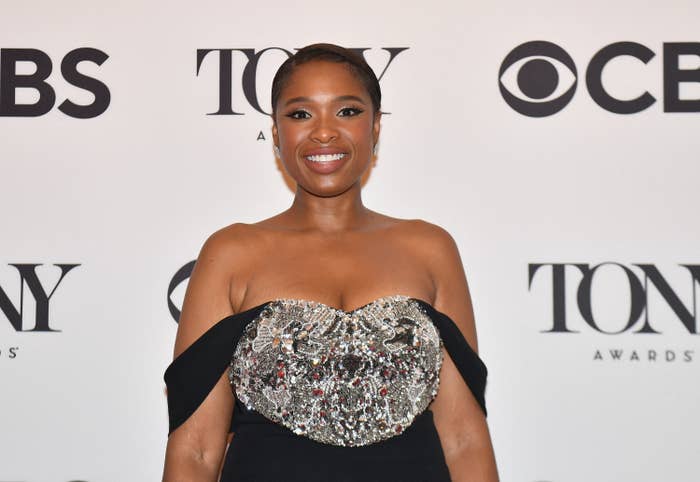 JHud smiling on the red carpet in an off-the-shoulder outfit