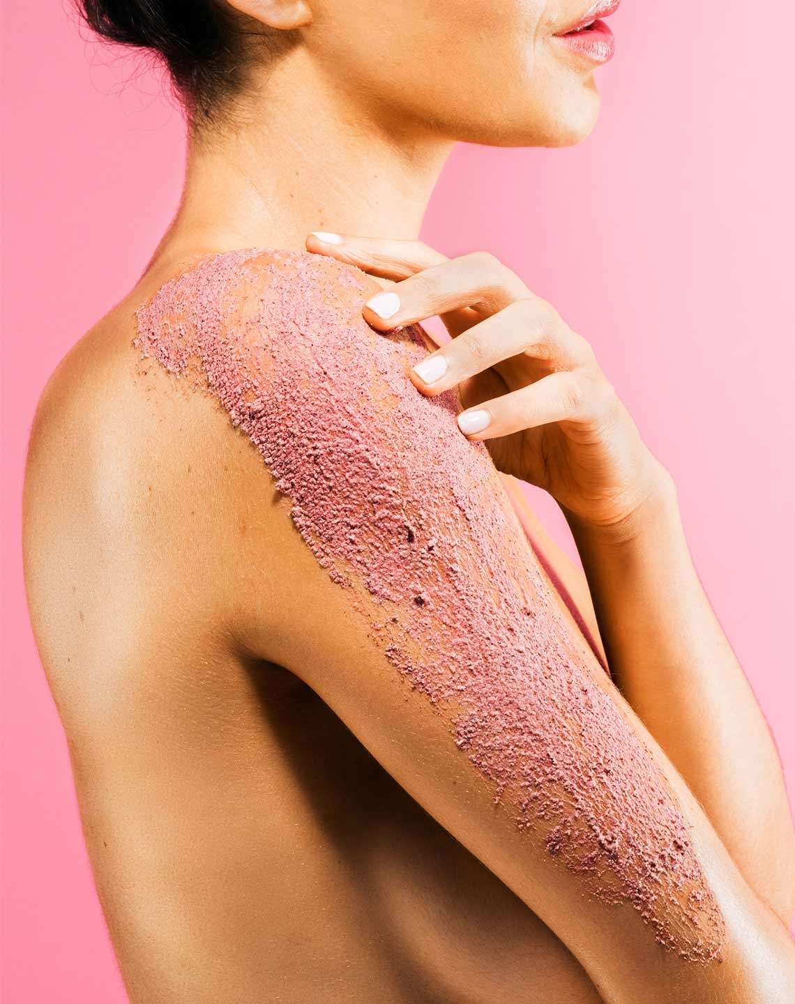 Model with pink body scrub on arm