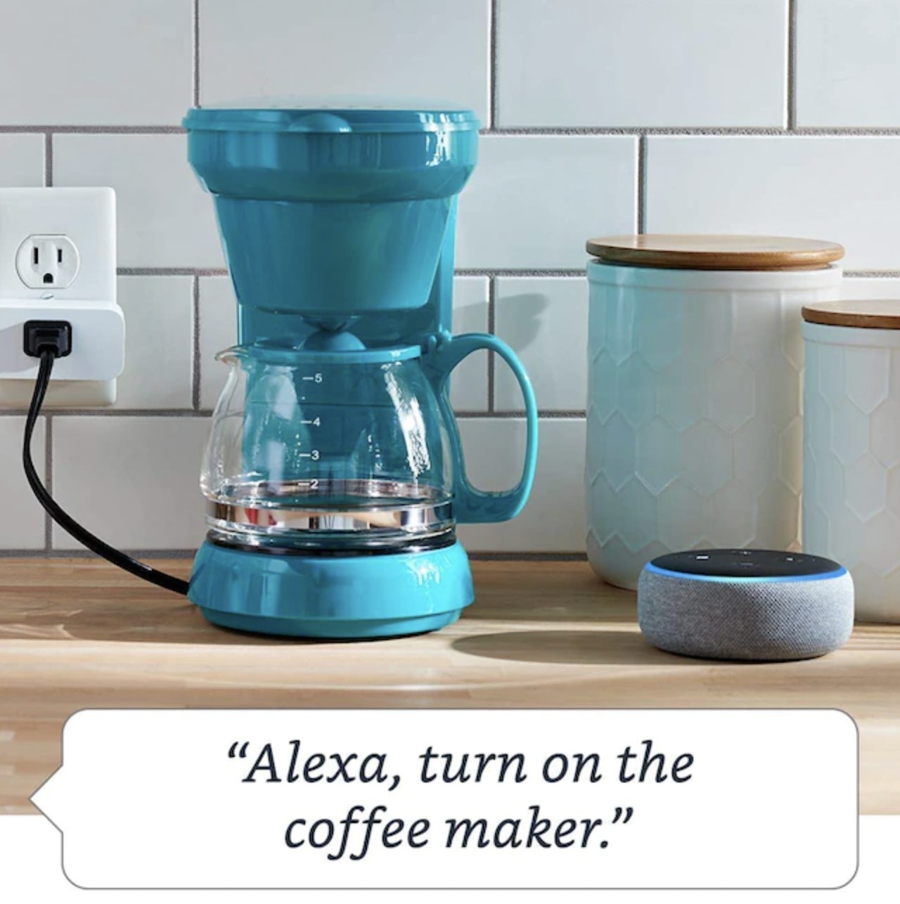 The smart plug hooked up to kitchen coffee maker with speech bubble reading &quot;Alexa, turn on the coffee maker.&quot;