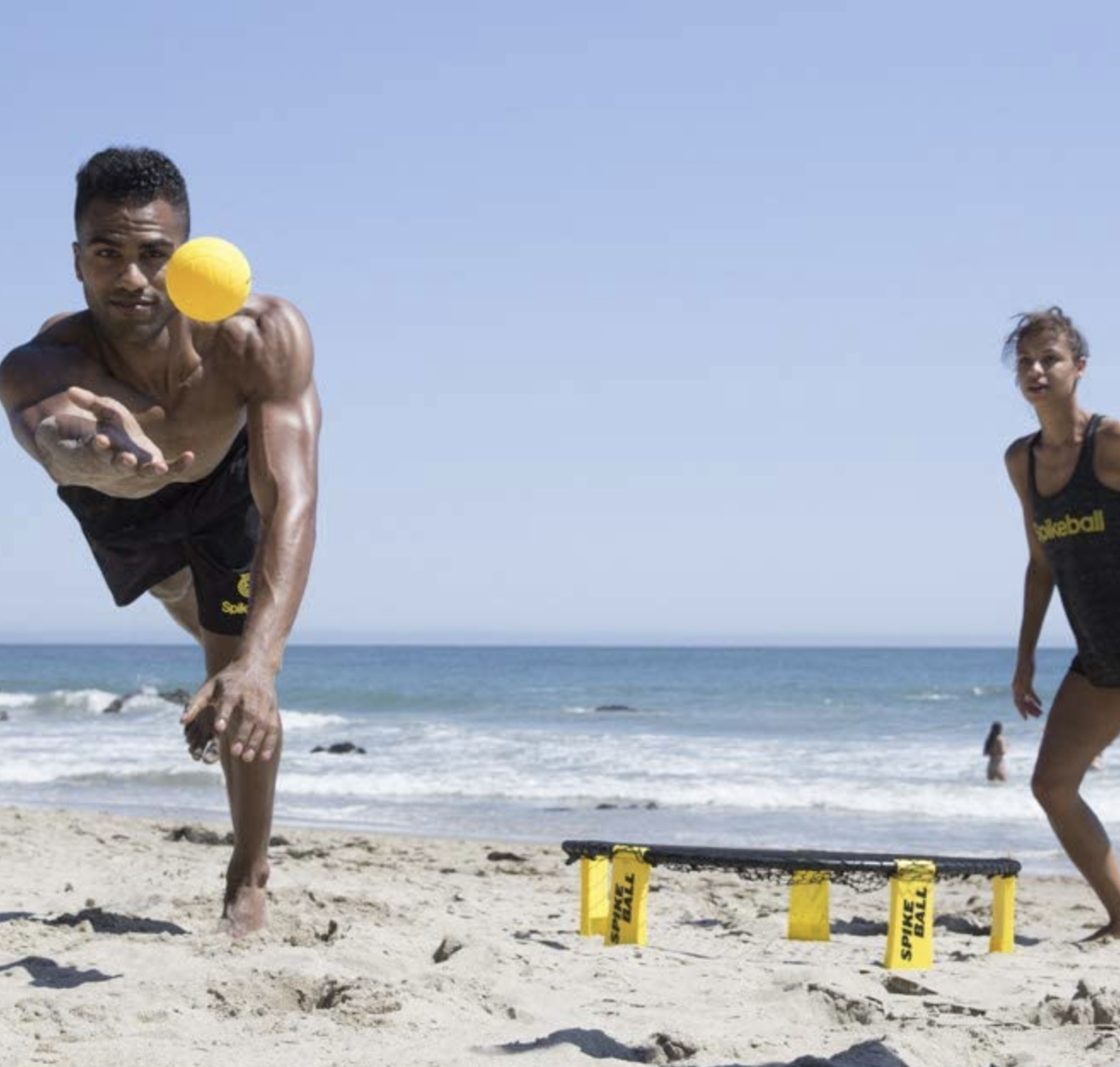 two people playing spike ball on the beach