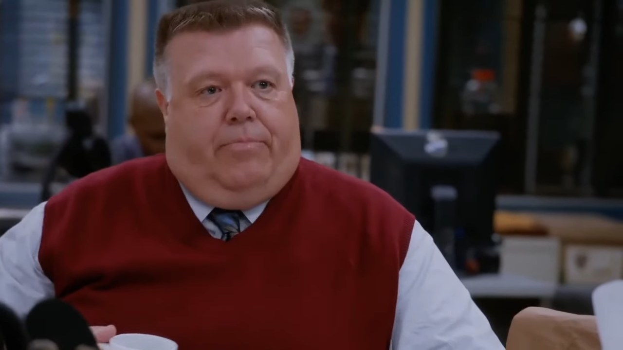 Scully sitting at his desk in a red sweater vest in &quot;Brooklyn Nine-Nine&quot;