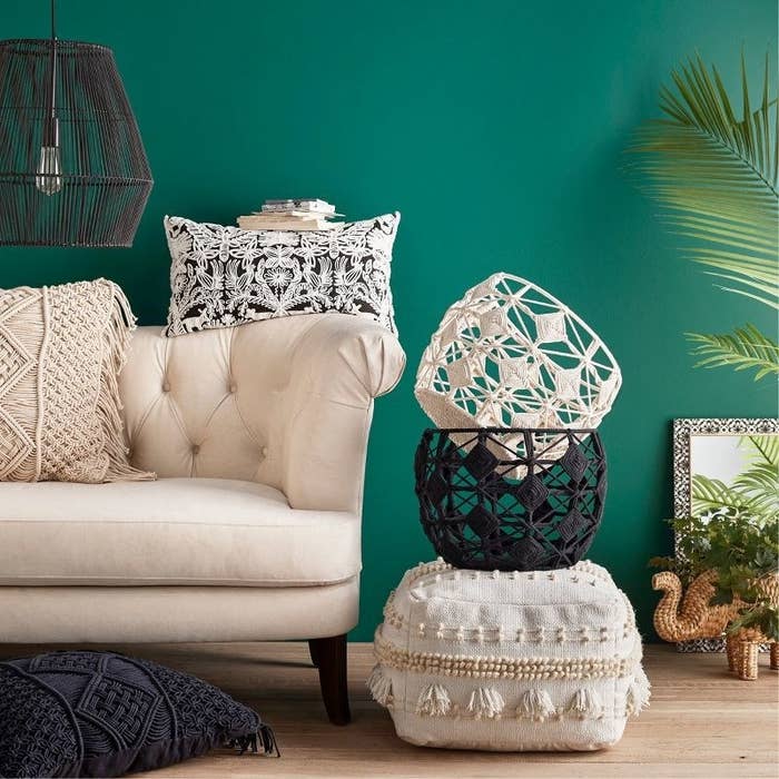 White ottoman on hardwood floor of living room with one black and one white basket on top
