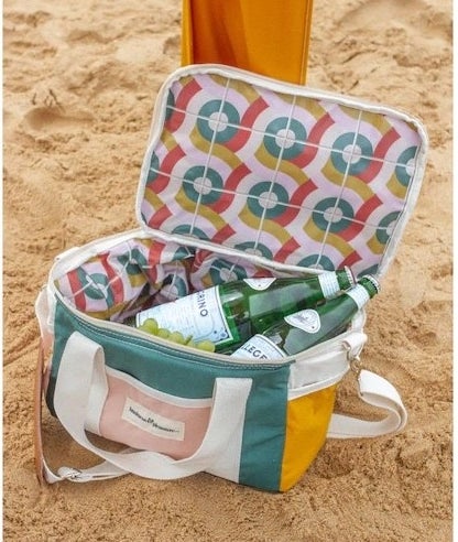 The cooler on the sand at a beach with waters in it