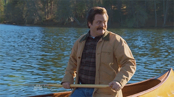 a gif of Ron Swanson from Parks and Rec paddling a canoe on a lake