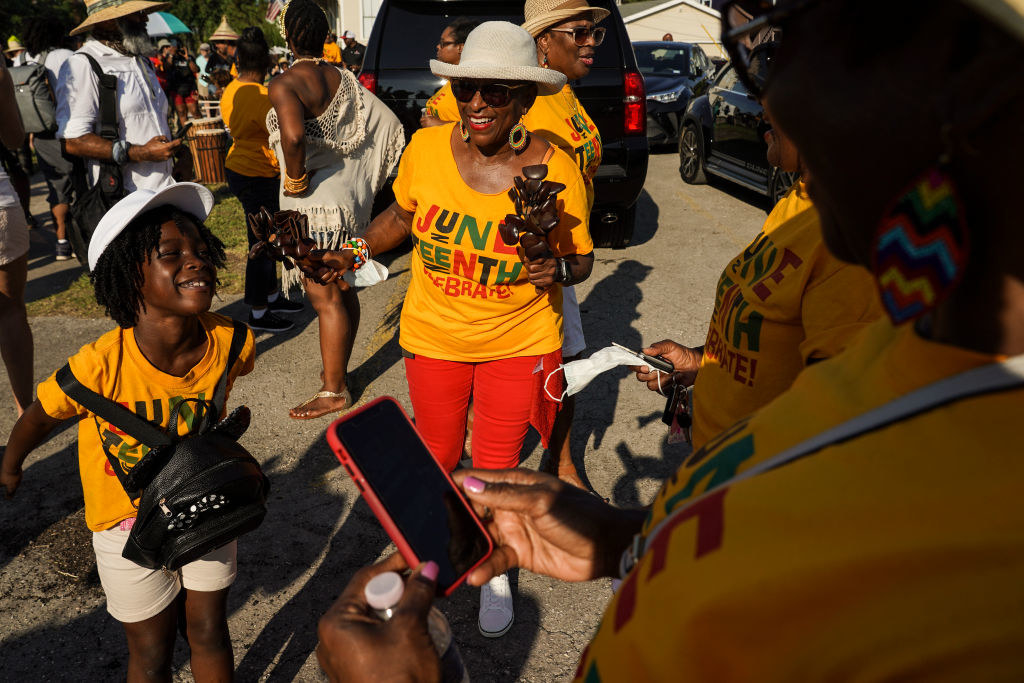 a family celebrates juneteenth along a parade route