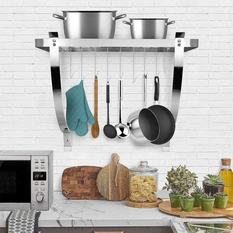The pot rack on the wall with pans and kitchen tools hanging off it