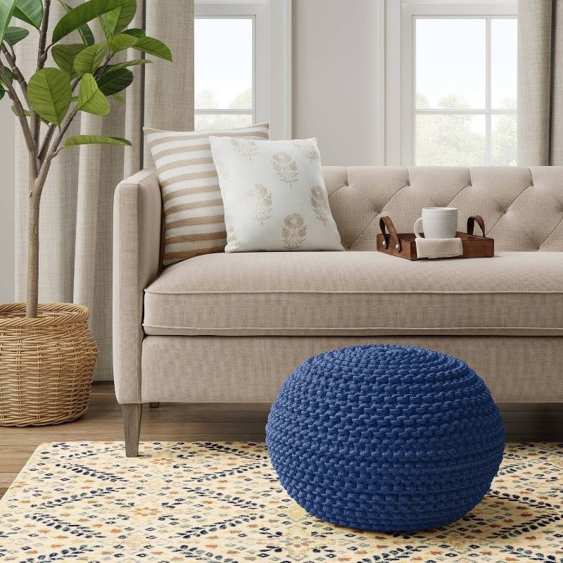 a blue knit pouf in a living room