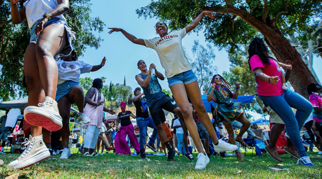 a group dances in the park during a juneteenth celebration
