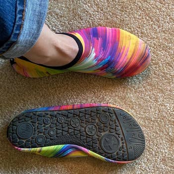 another reviewer wearing brightly colored shoes and showing the grippy backing