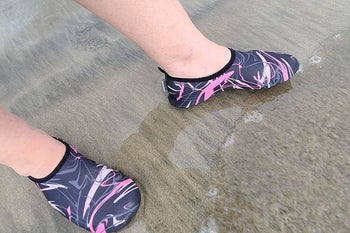 reviewer wearing the graphic designed shoes in wet sand