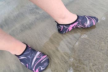 reviewer wearing the graphic designed shoes in wet sand