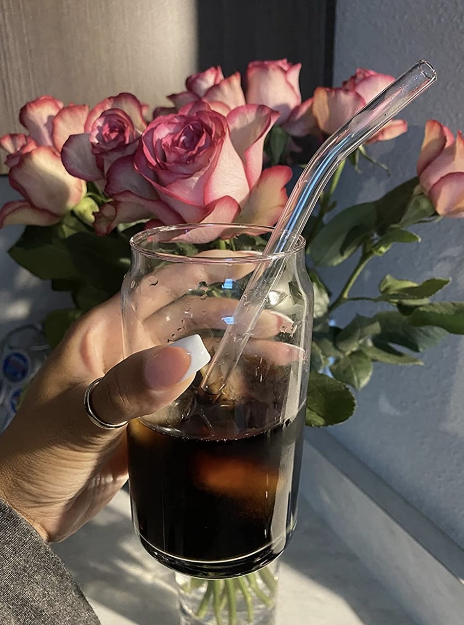 a reviewer holding the glass with cold brew coffee in it
