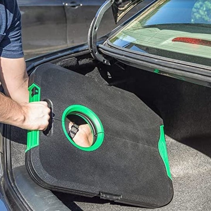 A person putting the small set into the trunk of their car