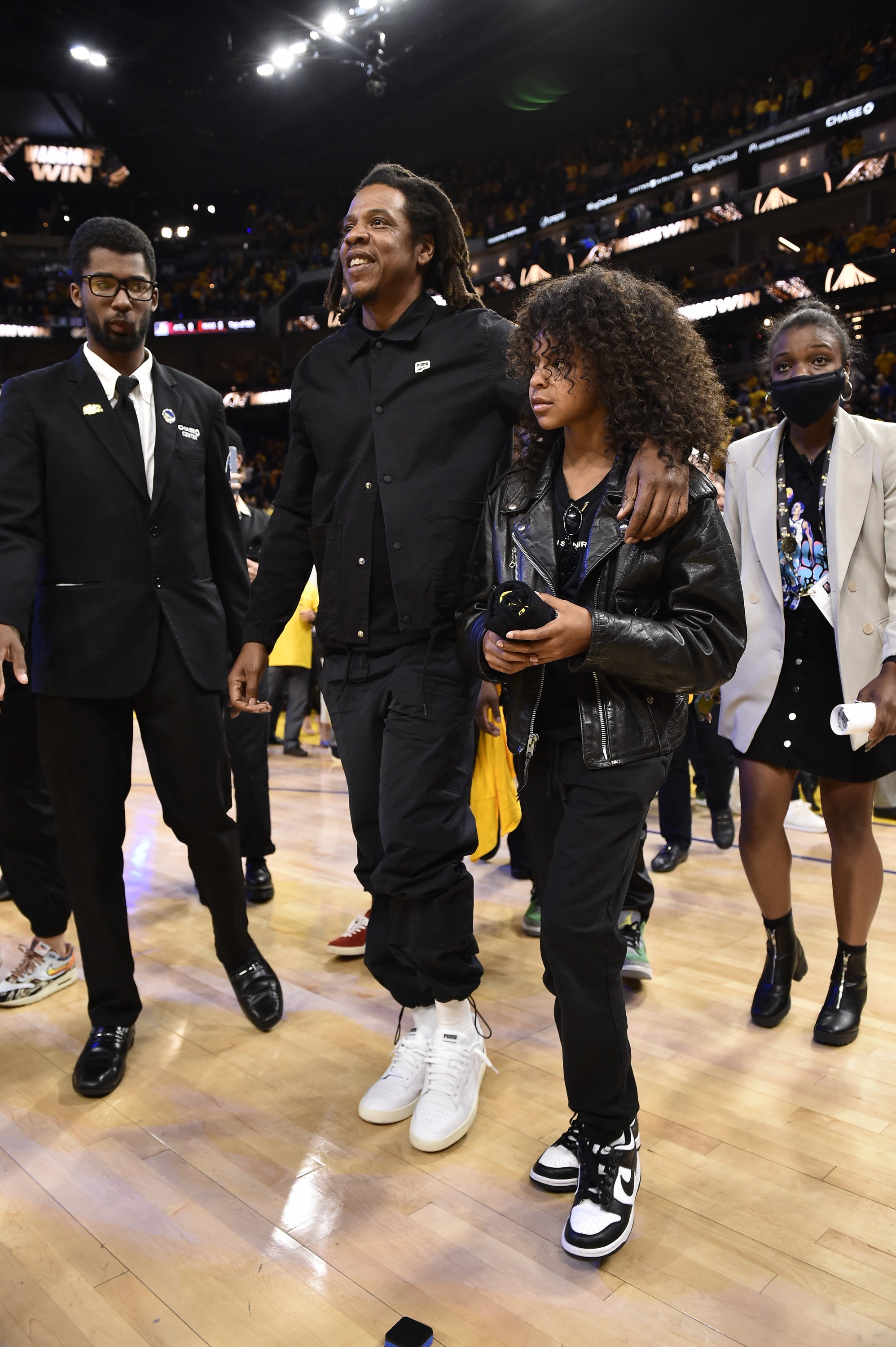 Jay-Z and Blue Ivy on the actual court, with security personnel around them