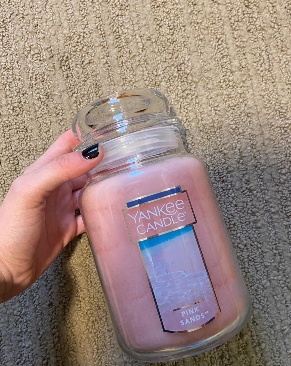 person holding the pink sands yankee candle