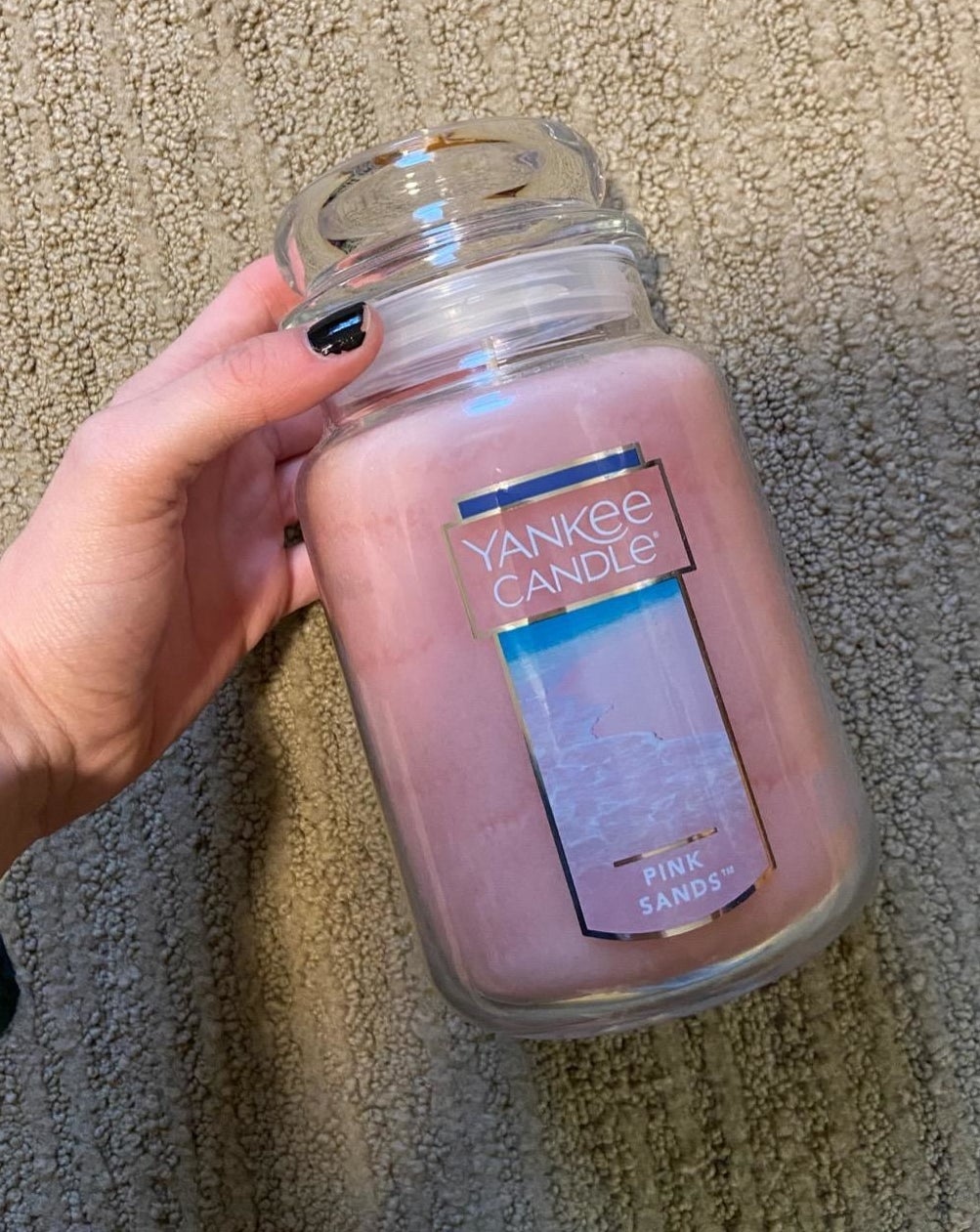 person holding the pink sands yankee candle