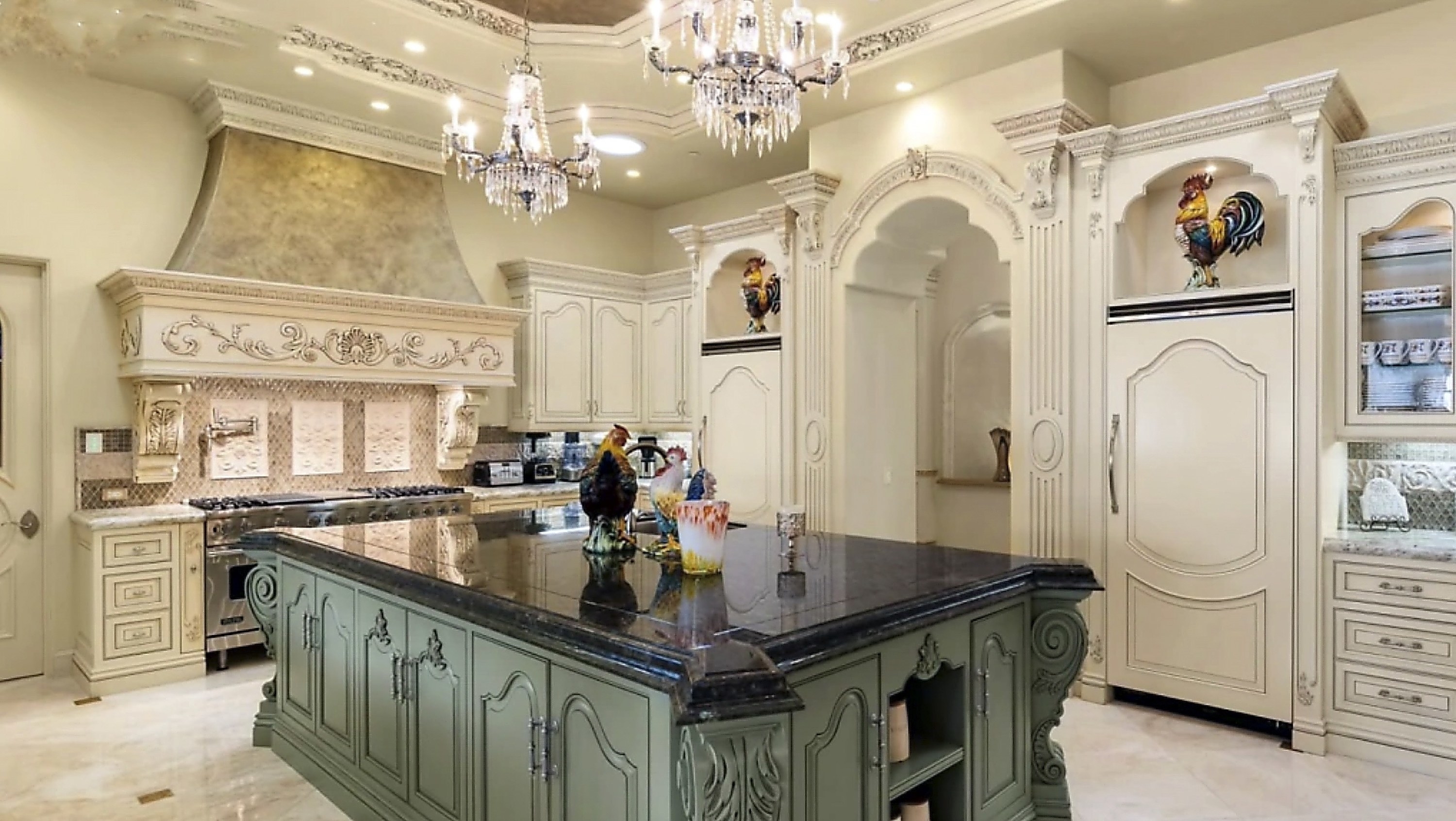 The kitchen island is directly across from the stove and is topped with thick marble