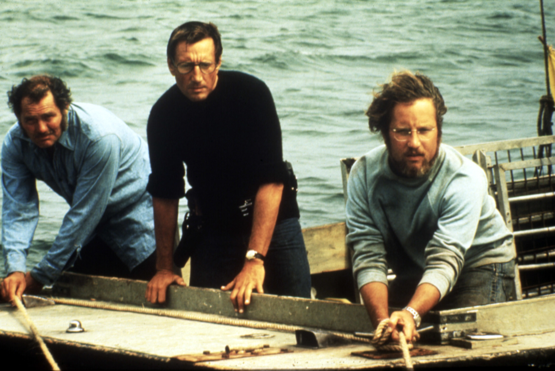 Three men looking disturbed on a boat