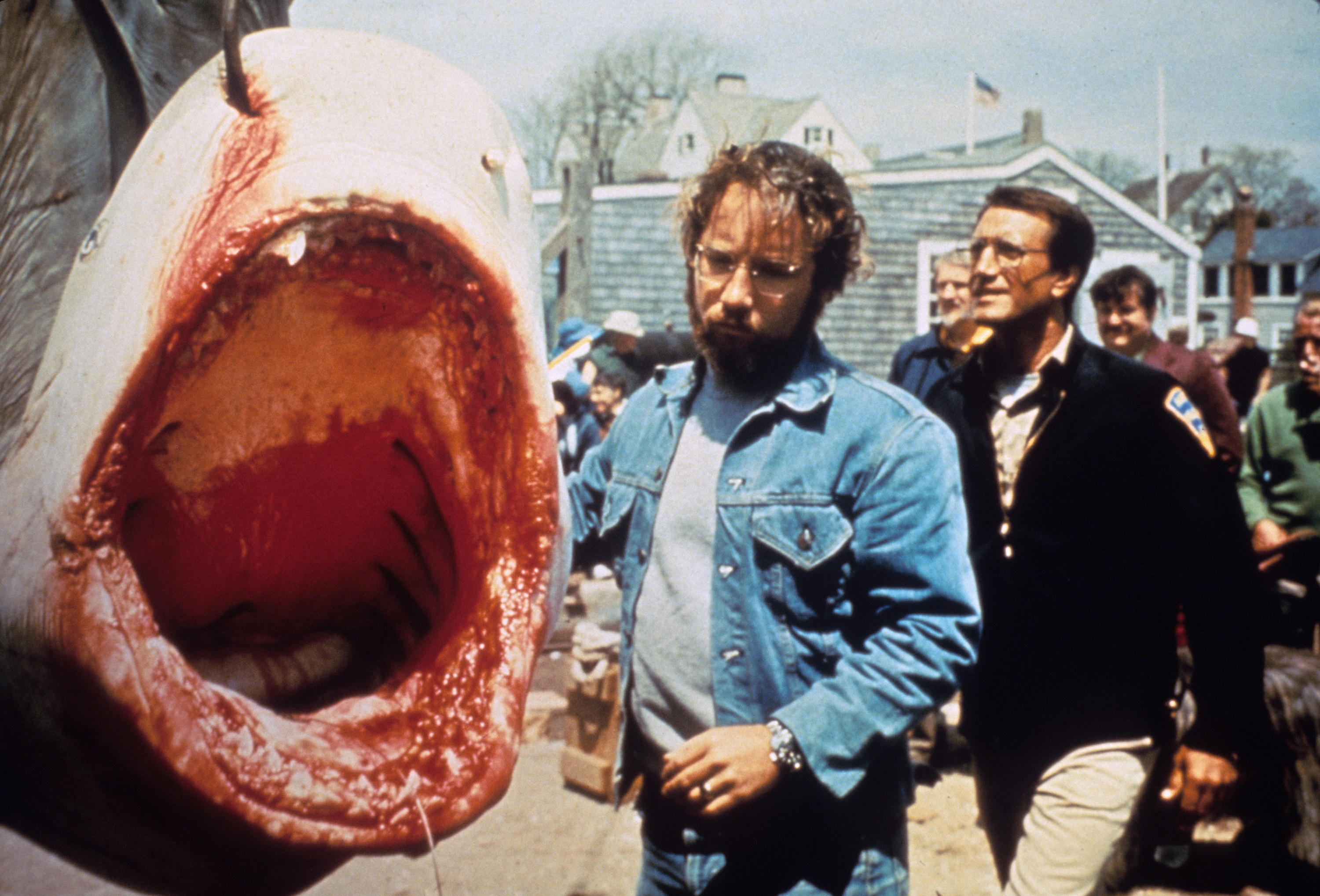 Two men standing beside a bloodied shark