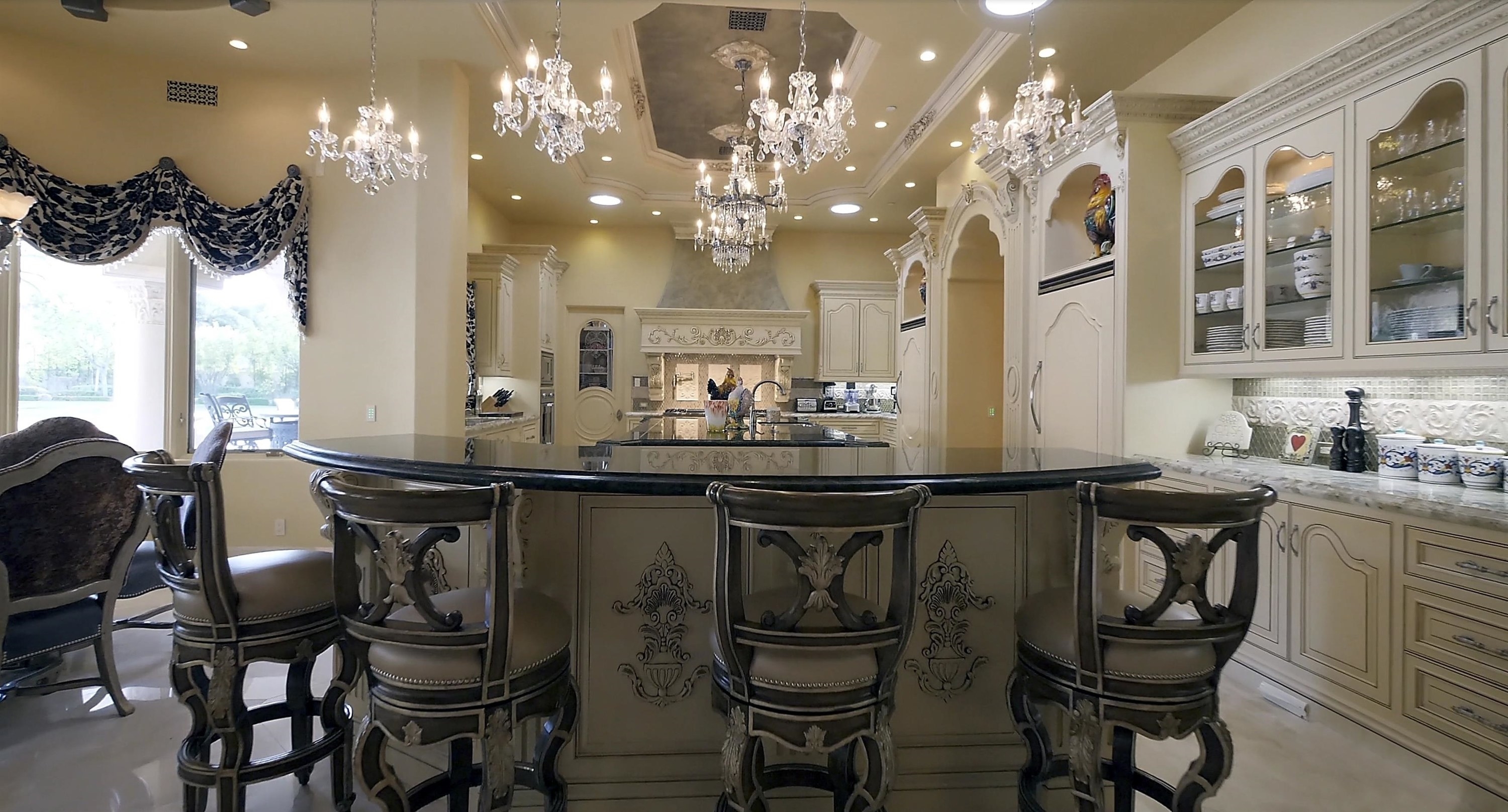 A different angle of the kitchen shows seven more chandeliers, multiple of which are hanging over the kitchen table