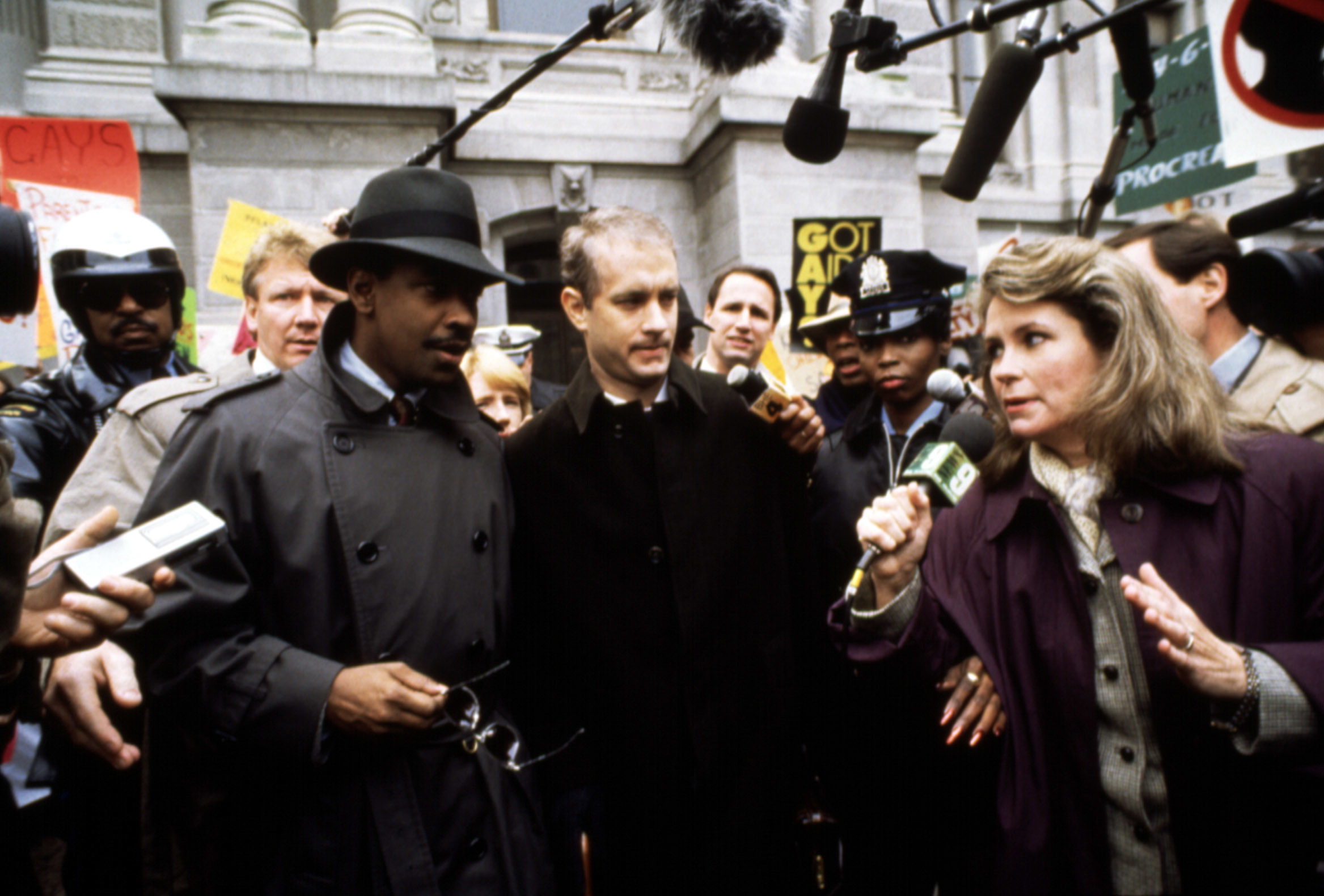 Tom and his lawyer walk through a crowd of press in the film